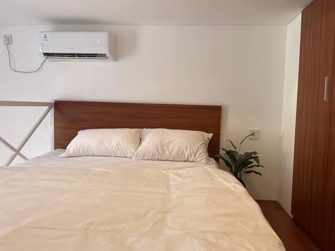 Loft bedroom with wood headboard