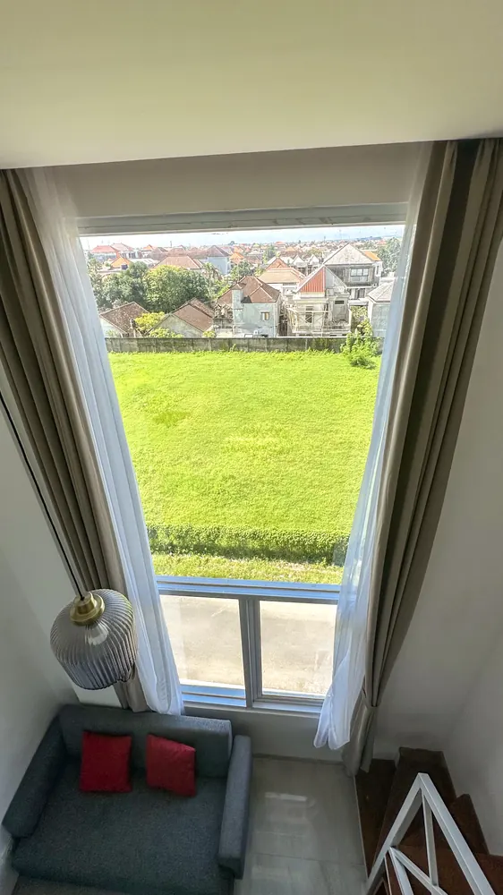 Tall window over open green fields