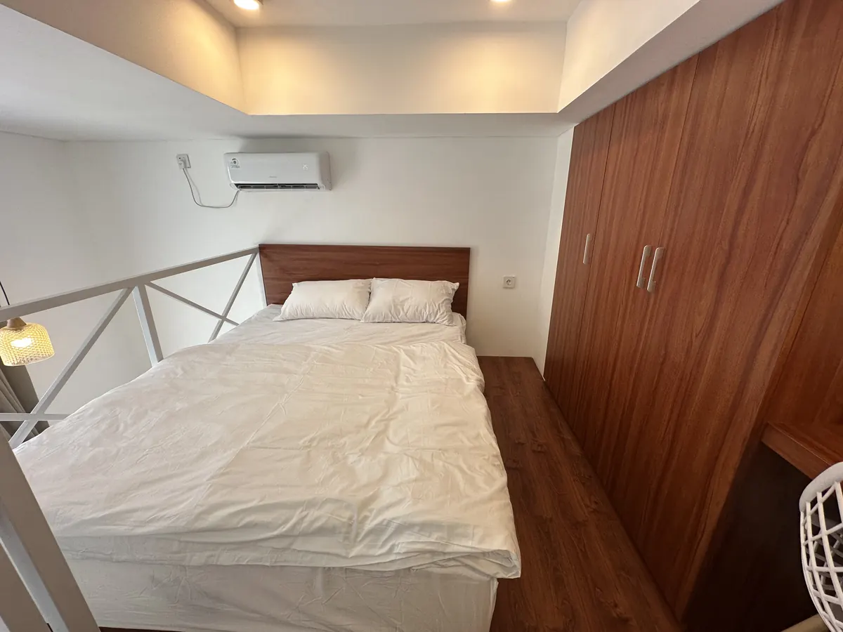 Loft bedroom behind the white X-pattern railing