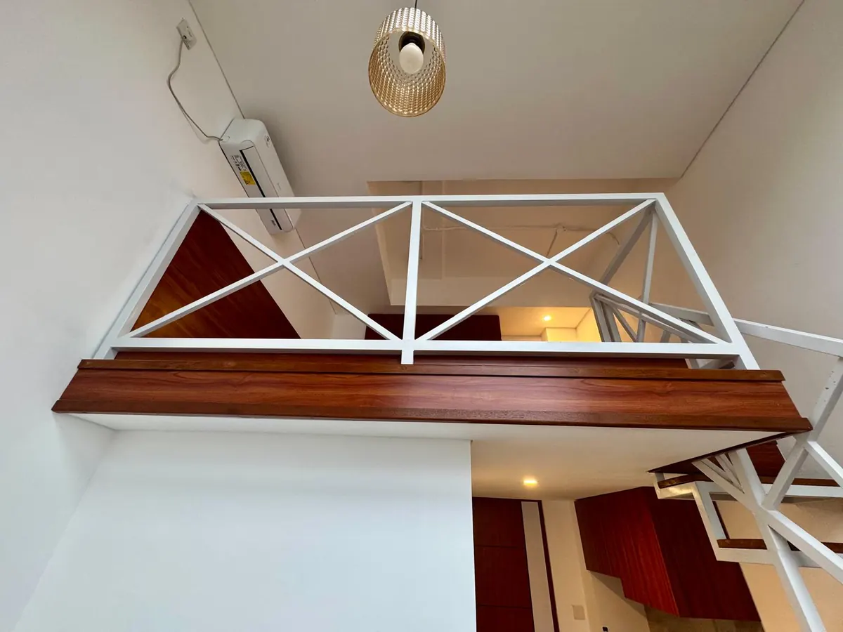Loft balcony with white X-pattern railing seen from below