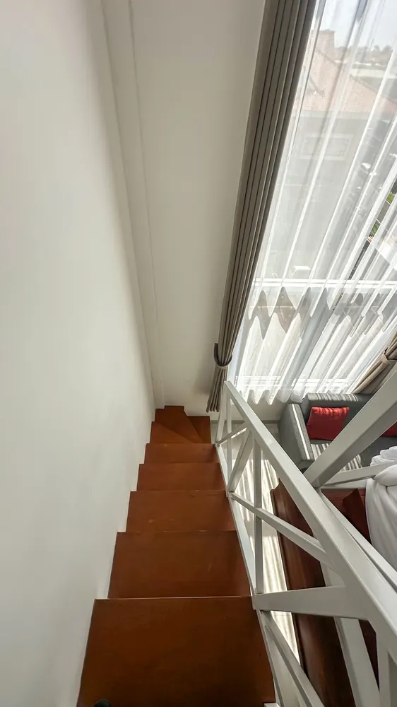 Staircase rising beside the tall window